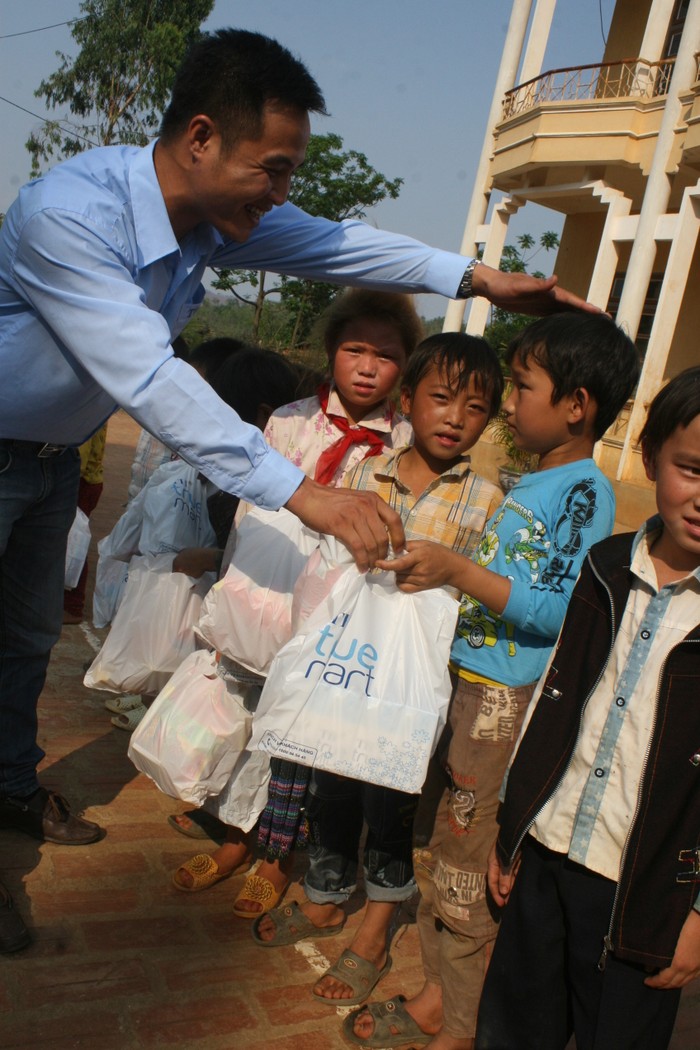 Anh Hà Danh Hồng - Giám đốc vùng Tây Bắc 3 thuộc chuỗi thực phẩm TH True Milk trao những suất quà cho các em học sinh trường Tiểu học Nà Bó 2.